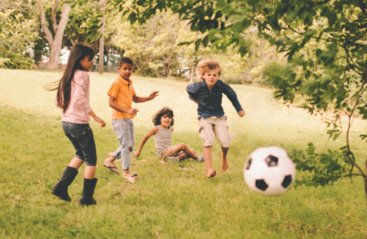 Children playing with a football in in a field
